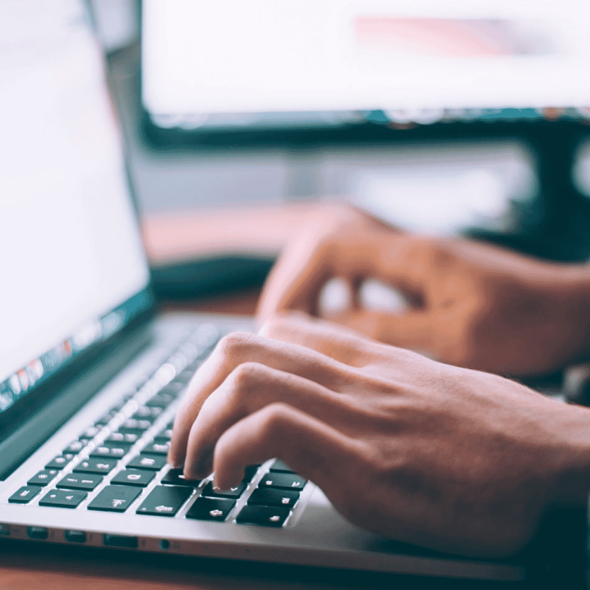 hands typing on a laptop