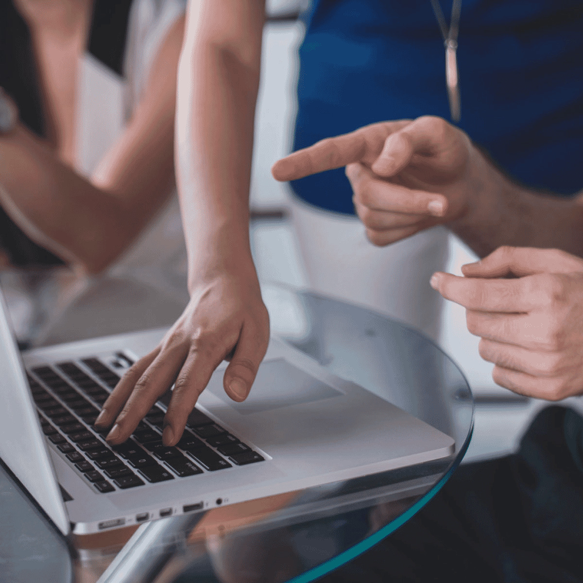 Group gathered around a laptop with someone pointing at the screen
