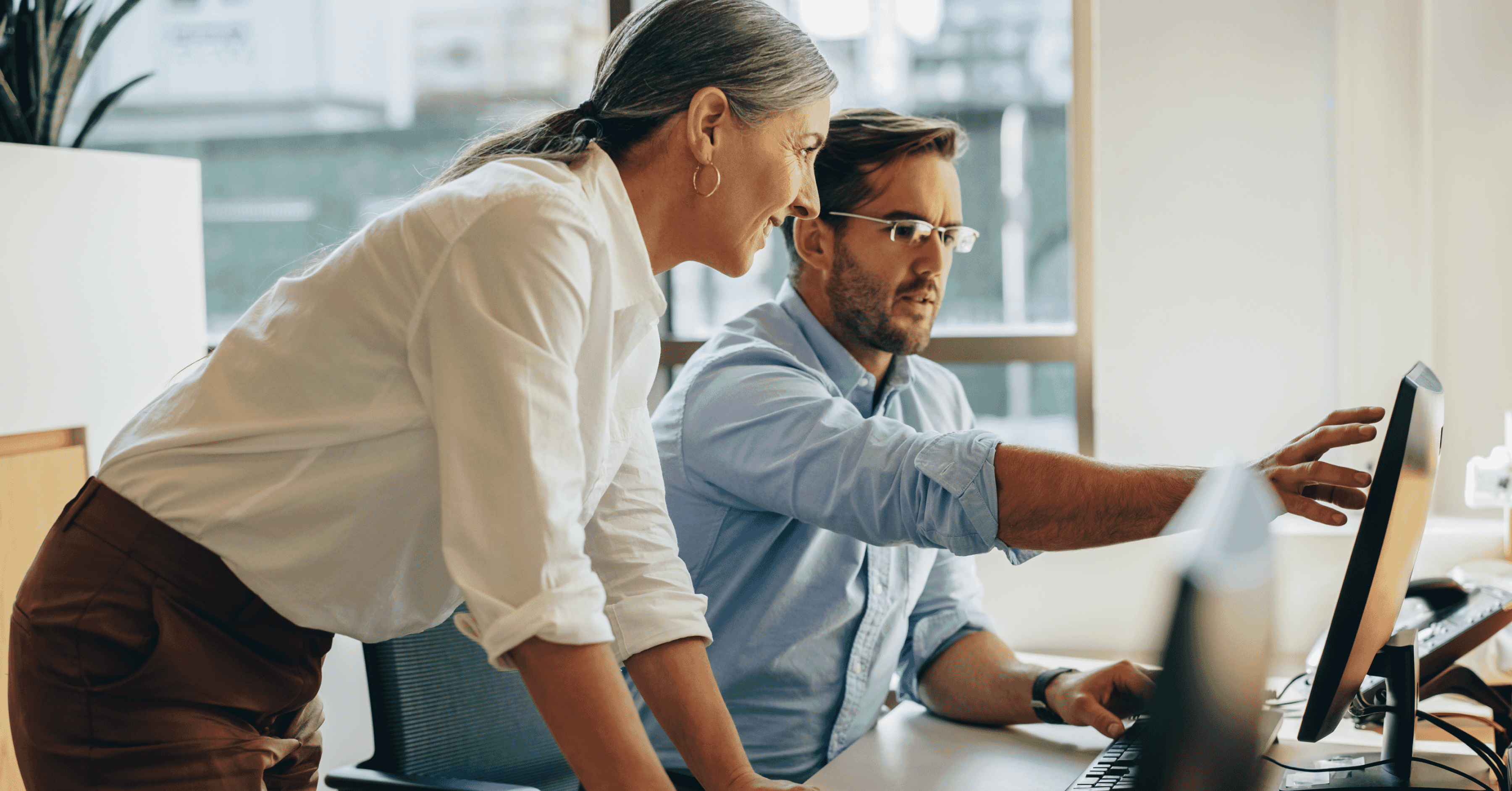 image of two colleagues looking at a computer screen
