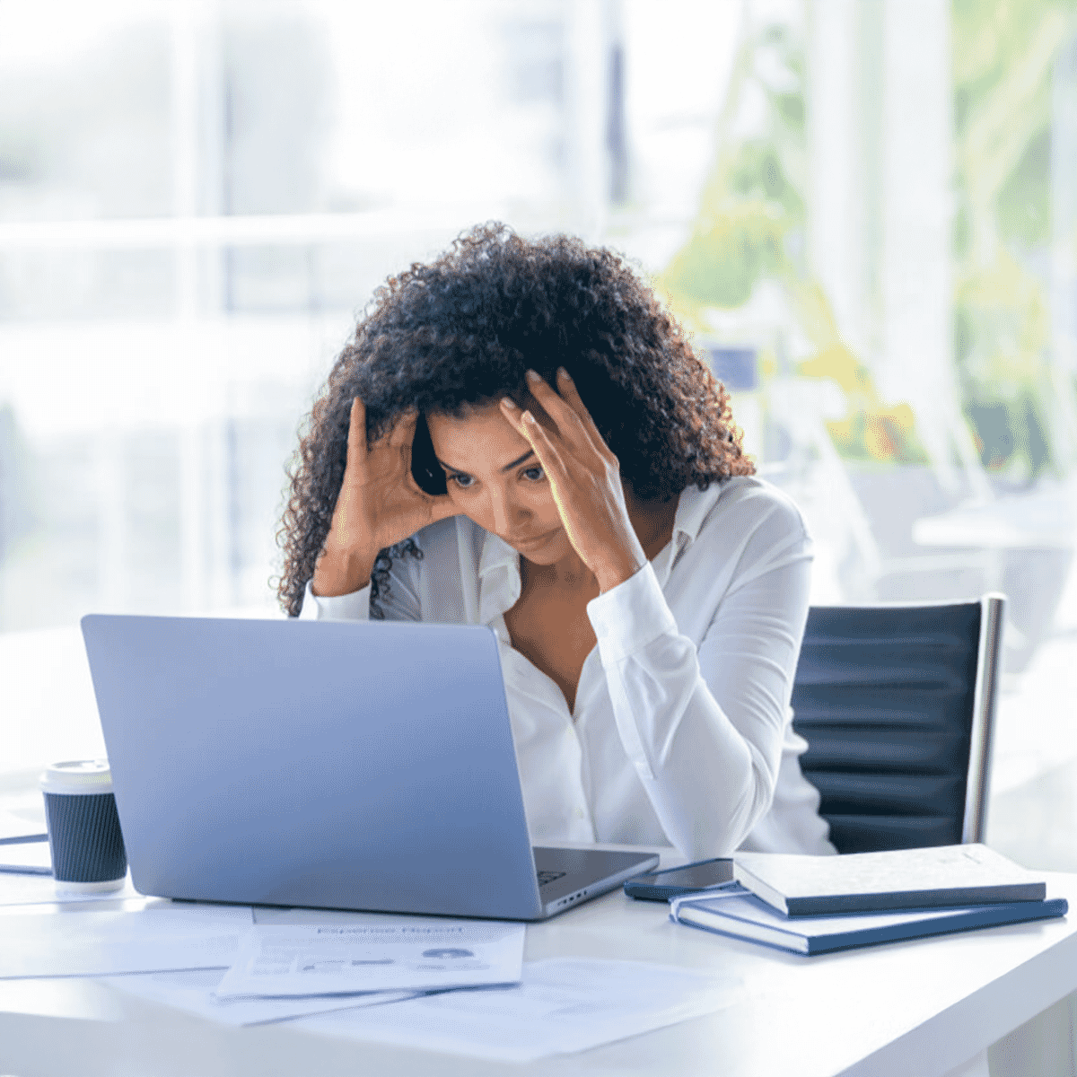 worker at laptop holding head