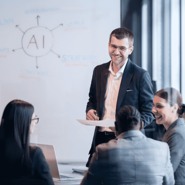 usiness team in a meeting discussing AI strategy with a whiteboard diagram in the background.