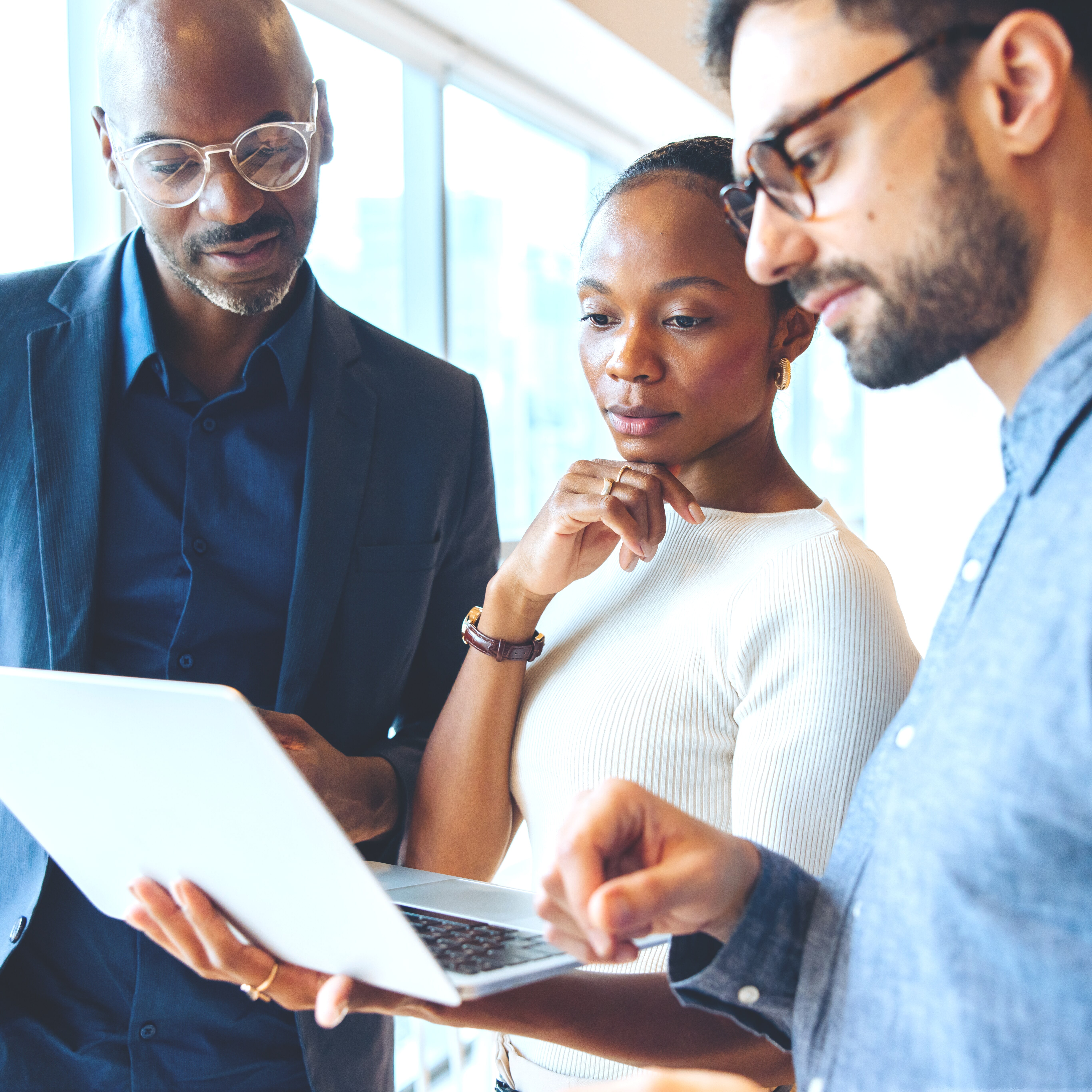 Corporate team working together around a laptop.