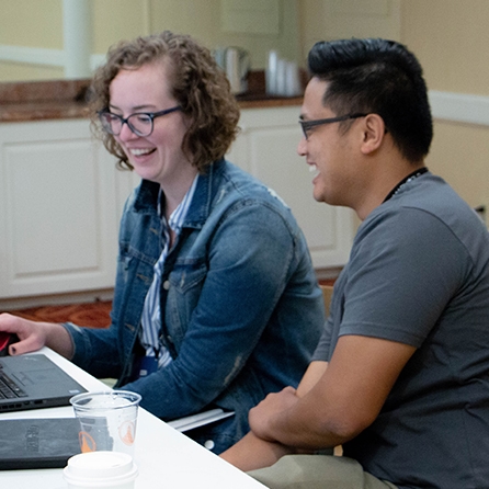 People smiling during a one on one session in the Technical Support Lounge