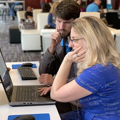 Photo of people smiling during a One to One session in the MadWorld Technical Support Lounge