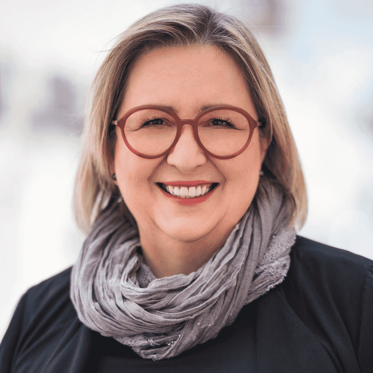 headshot of Rahel Bailie in black blazer with red framed glasses