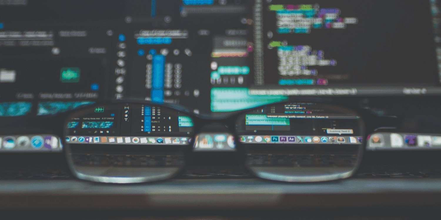 view of a laptop screen through glasses placed on the keyboard