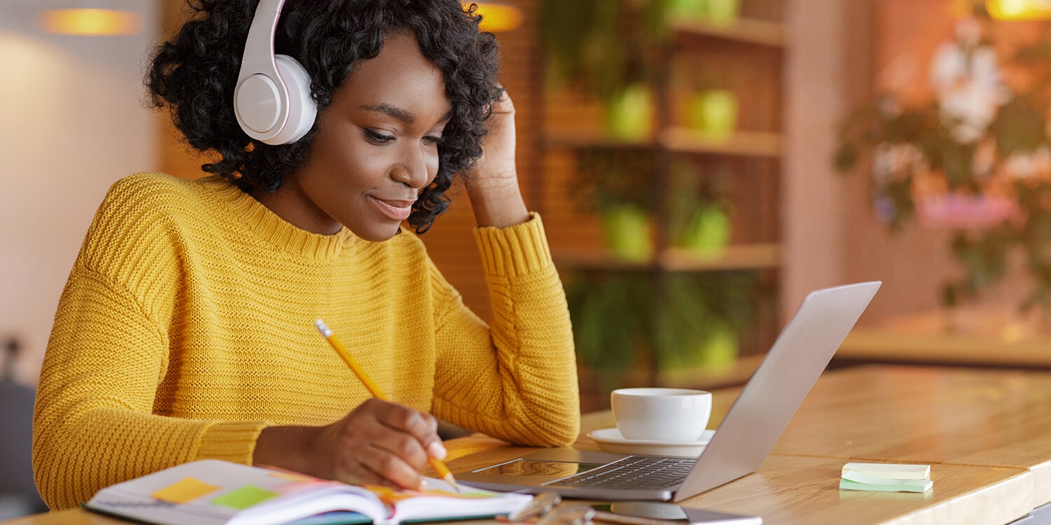 Closeup of someone clicking a mouse and taking notes