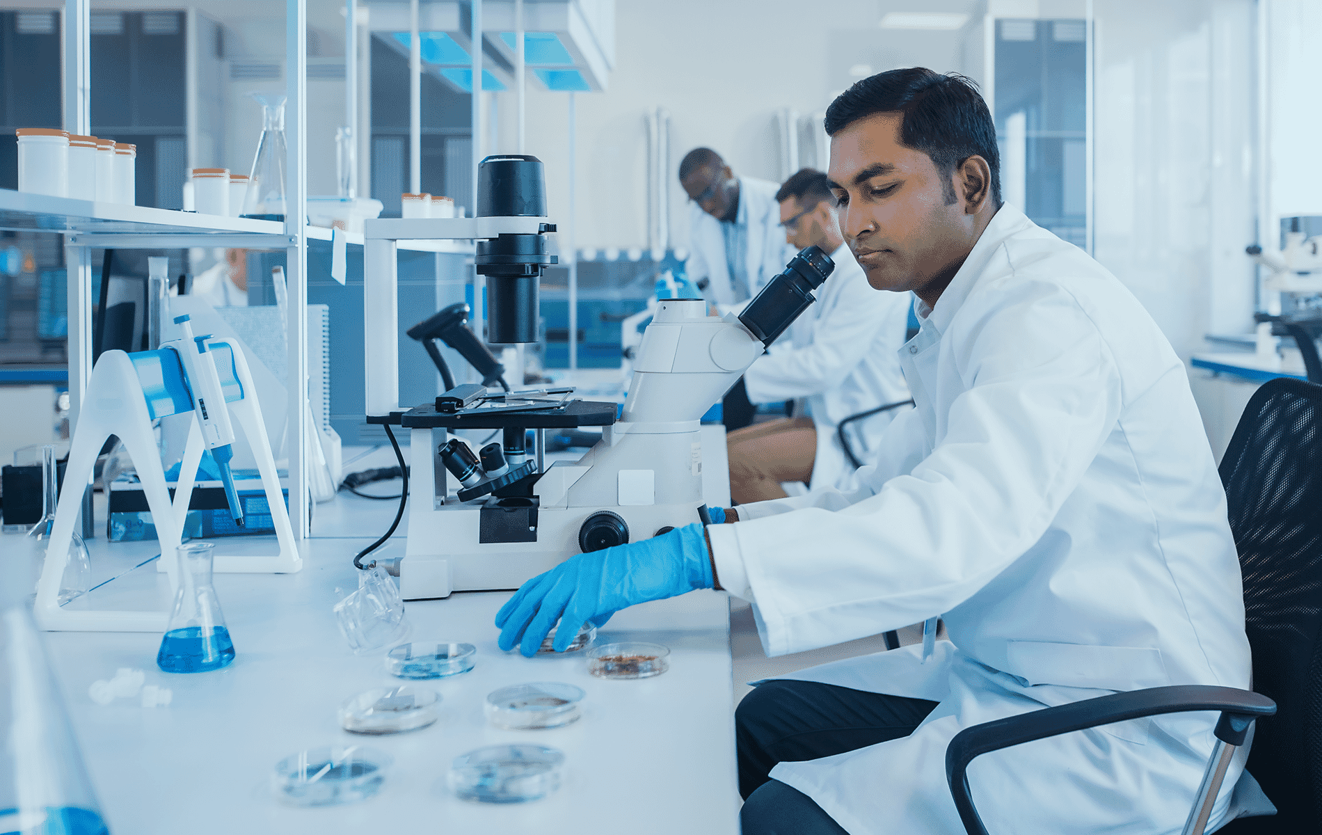 Image of a lab worker looking into a microscope