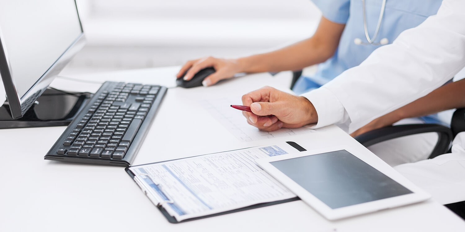 Closeup of someone clicking a mouse and taking notes