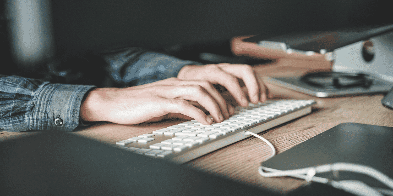 Someone hands typing on a keyboard